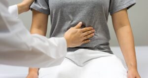Nurse checking a patient's level of pain in their stomach