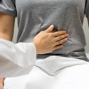 Nurse checking a patient's level of pain in their stomach