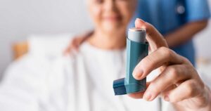 A woman in the hospital with an inhaler